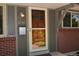 Close-up of the front door, featuring a wood door with glass accents, modern mailbox, and exterior lighting at 8292 E Lehigh Dr, Denver, CO 80237