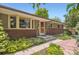 Charming single-story home featuring a brick facade, updated windows, and a beautifully landscaped walkway at 8292 E Lehigh Dr, Denver, CO 80237