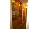 Hallway featuring wooden floors, built in shelves with under cabinet doors, and an interior door at 8292 E Lehigh Dr, Denver, CO 80237
