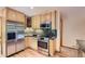Kitchen featuring stainless steel appliances, wooden cabinets, granite countertops, and hardwood floors at 8292 E Lehigh Dr, Denver, CO 80237