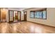 Bright living room with hardwood floors, large windows, and wood-trimmed french doors for a classic look at 8292 E Lehigh Dr, Denver, CO 80237