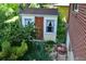 Quaint garden shed featuring wood door, two small windows, and surrounded by greenery at 8292 E Lehigh Dr, Denver, CO 80237