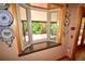 View from inside a cozy bay window, looking out onto a spacious wood porch and lush green trees at 8292 E Lehigh Dr, Denver, CO 80237