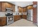Charming kitchen with wood cabinets, subway tiles, and modern stainless steel appliances at 1777 Spruce St, Denver, CO 80220