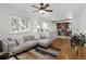 Bright living room featuring a comfortable grey couch, wood floors, and a ceiling fan at 1777 Spruce St, Denver, CO 80220
