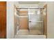 Bathroom with showerhead over tub with glass sliding doors and neutral tile at 2960 Shadow Creek Dr # 201, Boulder, CO 80303