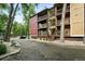 Multi-level condo building with balconies, wood siding, and lush greenery surrounding the property at 2960 Shadow Creek Dr # 201, Boulder, CO 80303