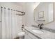 Elegant bathroom with a hexagon mirror, white vanity, and bathtub with shower features at 6429 Stable View St, Castle Pines, CO 80108
