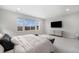 Spacious bedroom featuring carpet, a large window with neighborhood views, a TV, and a dresser at 6429 Stable View St, Castle Pines, CO 80108