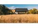 Modern shelter surrounded by golden fields and lush trees, offering a serene escape at 6429 Stable View St, Castle Pines, CO 80108