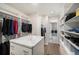 Organized walk-in closet with custom shelving, a center island, and access to the laundry room at 6429 Stable View St, Castle Pines, CO 80108