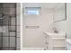 Bathroom with stylish gray-scale tile shower, vanity with modern fixtures, and bright natural light from the window at 8075 Sunset Dr, Lakewood, CO 80214