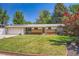 Charming ranch style home featuring a brick facade, solar panels, and a well-manicured front lawn at 8075 Sunset Dr, Lakewood, CO 80214
