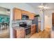 Stylish kitchen with stainless steel appliances, wood cabinets, and an open dining area at 8075 Sunset Dr, Lakewood, CO 80214