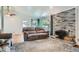 Bright living room with hardwood floors, brick fireplace, and large windows at 8075 Sunset Dr, Lakewood, CO 80214