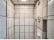 Enclosed shower with square beige tiles with gray grout, shower head and soap nook at 8075 Sunset Dr, Lakewood, CO 80214
