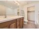 Bathroom with double vanity, large mirror, toilet, and shelving unit at 1313 S Clarkson St # 205, Denver, CO 80210