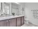 Bright bathroom with double sinks, gray cabinets, and a neutral-toned tile floor at 722 Eva Peak Dr, Erie, CO 80516