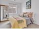 Cozy bedroom with a soft yellow quilt, throw pillows, and decoratively framed mirror at 722 Eva Peak Dr, Erie, CO 80516