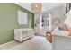 Neutral Bedroom with white crib, reading chair and a large window bringing in lots of natural light at 722 Eva Peak Dr, Erie, CO 80516