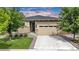 Charming single-story home with a stone facade, well-manicured lawn, and attached two-car garage at 722 Eva Peak Dr, Erie, CO 80516