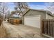 White garage door and light-green garage nestled in a yard with wood fence at 4017 King St, Denver, CO 80211