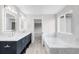 Bright bathroom showcasing double sinks, a standalone tub, and modern fixtures at 186 S 45Th Ave, Brighton, CO 80601