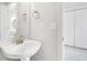 Clean and modern bathroom with a white pedestal sink, brass fixtures, and walk-in shower at 186 S 45Th Ave, Brighton, CO 80601