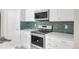 Well-equipped kitchen with stainless steel oven, microwave, and white cabinets and granite countertop at 186 S 45Th Ave, Brighton, CO 80601