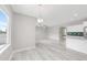 Bright, open-plan living room with modern lighting, large windows, open archway to kitchen and light wood-look floors at 186 S 45Th Ave, Brighton, CO 80601