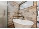 Modern bathroom featuring a freestanding tub, stone tile, glass shower and modern fixtures at 148 S Holman Way, Golden, CO 80401