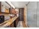 Bathroom featuring granite countertops, wood cabinets, and a glass-enclosed shower at 148 S Holman Way, Golden, CO 80401