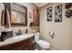 View of a guest bathroom with a granite countertop, a dark wooden cabinet, and artistic wall decor at 148 S Holman Way, Golden, CO 80401