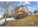 Townhouse with a mix of siding and brick, features a wooden deck, chimney, and a sloped yard at 148 S Holman Way, Golden, CO 80401