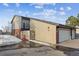 View of the side of a two story home with a brick exterior and a two car garage on a cloudy day at 148 S Holman Way, Golden, CO 80401