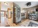 View of a hallway with light wood floors, a hutch, and a view into the kitchen on a sunny day at 148 S Holman Way, Golden, CO 80401