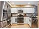 Updated kitchen featuring stainless steel appliances, granite countertops, and stylish white cabinetry at 148 S Holman Way, Golden, CO 80401