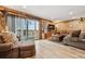 View of a cozy living room with wood paneled walls, hardwood floors, and access to a balcony at 148 S Holman Way, Golden, CO 80401