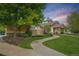 Charming exterior with a stone foundation, red siding, covered entryway, professional landscaping, and a curved sidewalk at 12951 Vallejo Cir, Denver, CO 80234