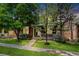 Manicured front lawn showcasing the home's charming facade with mature trees and sidewalk access at 12951 Vallejo Cir, Denver, CO 80234