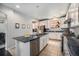 Well-lit kitchen featuring granite countertops, stainless steel appliances, and a central island with sink and dishwasher at 12951 Vallejo Cir, Denver, CO 80234