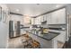Bright kitchen with white cabinets, stainless steel appliances, and a large island with counter seating at 12951 Vallejo Cir, Denver, CO 80234