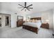 Stylish main bedroom with a dark wood bed frame, plush carpet, and ample natural light at 12951 Vallejo Cir, Denver, CO 80234