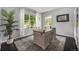 Bright home office featuring large windows, stylish desk, and a lush green plant at 12951 Vallejo Cir, Denver, CO 80234