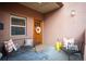Inviting entryway featuring bench seating, decorative pillows, and a charming wood door with wreath at 469 Elati St, Denver, CO 80204