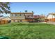A large backyard with a deck, patio, and lush green grass at 2034 S Idalia St, Aurora, CO 80013
