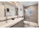 This modern bathroom features a dual sink vanity, decorative wall tile and a glass-enclosed shower at 2034 S Idalia St, Aurora, CO 80013