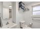 Bright bathroom with a single sink, mirror, open shelves, and a toilet at 2034 S Idalia St, Aurora, CO 80013