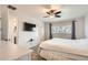 A spacious bedroom features a window, a TV, neutral paint and an ensuite bathroom at 2034 S Idalia St, Aurora, CO 80013