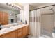 Well-lit bathroom with double sinks and a shower-tub combination at 10180 Blue Sky Trl, Conifer, CO 80433